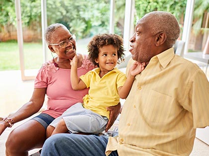 Mature couple playing with their young grandson